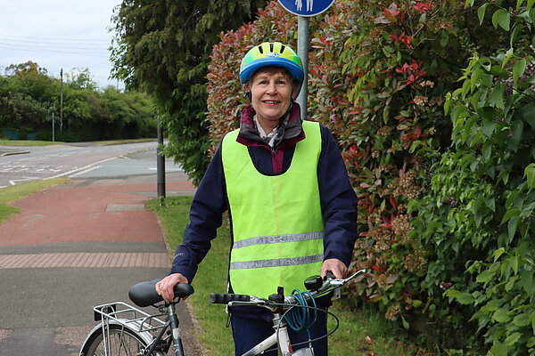 Catherine standing with a bike