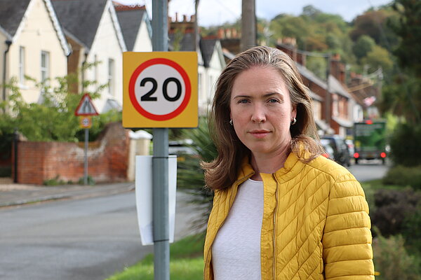 Anna Crabtree in front of a 20mph speed limit sign