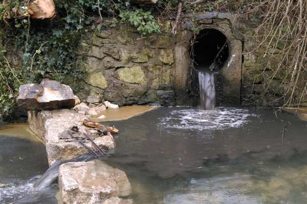 Pipe discharging sewage into stream