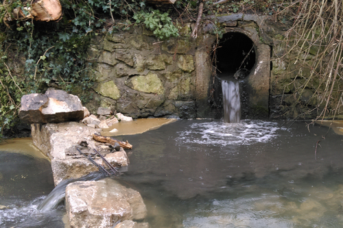 pipe discharging sewage into river