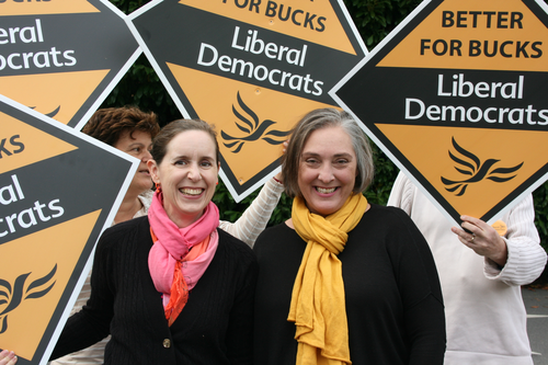 Christine and Susanne standing in front of Lib Dem sign Boards